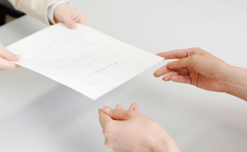 Picture of someone handing over a contract